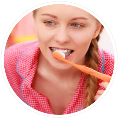 Girl with braces brushing her teeth