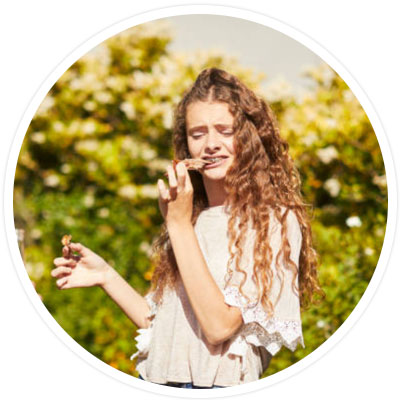 Girl with braces eating food.