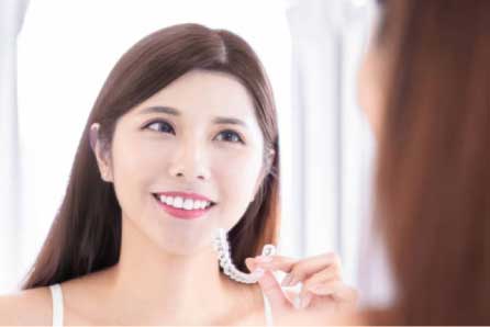 Girl holding invisible braces - faqs