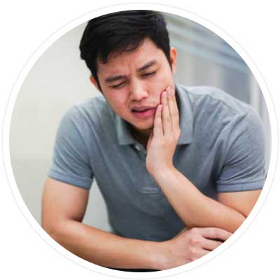 TMJ Treatment - man holding jaw in pain.